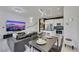 Open-concept living space with modern decor, a sleek black leather sofa and white tile floors at 30 Via Vasari # 102, Henderson, NV 89011