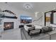 Cozy living room with a fireplace, a large TV, and comfortable seating on white tiled floor at 30 Via Vasari # 102, Henderson, NV 89011