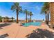 Inviting outdoor pool area with comfortable seating, a fireplace and serene mountain views at 30 Via Vasari # 102, Henderson, NV 89011
