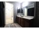 Functional bathroom featuring a sleek vanity with double sinks, mirror, and separate shower area at 3008 Saint George St # B, North Las Vegas, NV 89030
