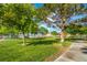 Lush park with green lawn, mature trees, and a view of waterfront homes and lake at 3104 Waterview Dr, Las Vegas, NV 89117