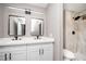 Bathroom features a double sink vanity with two mirrors, upgraded shower tile, and light fixture at 3105 Birch Hill Ct, Las Vegas, NV 89134