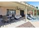 Expansive covered patio includes an outdoor kitchen, comfortable seating, and a view of the pool at 3194 Lapis Beach Dr, Las Vegas, NV 89117