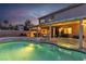 Beautiful backyard pool and spa with an illuminated patio and garden at twilight at 3194 Lapis Beach Dr, Las Vegas, NV 89117