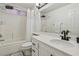Bright bathroom with a tub shower combo, single sink vanity with black fixtures and white tiling at 3194 Lapis Beach Dr, Las Vegas, NV 89117