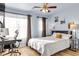 Bright bedroom featuring a cozy bed, natural light, and a functional desk area with modern decor at 3194 Lapis Beach Dr, Las Vegas, NV 89117