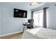 A bedroom featuring a work space, TV and large window for natural light at 3194 Lapis Beach Dr, Las Vegas, NV 89117