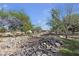 Scenic view of the community park with mature trees, walking paths, and natural rock features at 3194 Lapis Beach Dr, Las Vegas, NV 89117