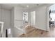 Bright hallway with wood floors, white walls, and white railings, leading to multiple rooms at 3194 Lapis Beach Dr, Las Vegas, NV 89117