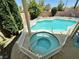 Close-up of backyard pool and spa with a white picket fence and a lush green landscape at 3194 Lapis Beach Dr, Las Vegas, NV 89117