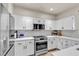 Kitchen features stainless steel appliances, white cabinets and mosaic backsplash at 3194 Lapis Beach Dr, Las Vegas, NV 89117