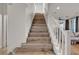 Inviting staircase leading to upper level with hardwood steps and white banister at 3194 Lapis Beach Dr, Las Vegas, NV 89117