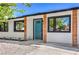 Close up view of the house featuring a minimalist landscaped yard, painted white stucco, and a welcoming blue front door at 333 Rossmoyne Ave, North Las Vegas, NV 89030