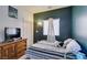 This is a bedroom with a comfortable bed, a wooden dresser, and a window with blinds at 3553 Terneza Ave, North Las Vegas, NV 89081