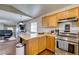 Open-concept kitchen and living room area with wooden cabinets, stainless steel appliances, and hardwood floors at 3553 Terneza Ave, North Las Vegas, NV 89081