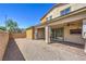 This backyard features low-maintenance gravel, a covered patio, and a brick perimeter wall for privacy at 406 Gracious Way, Henderson, NV 89011