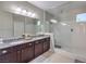 Modern bathroom featuring a dual sink vanity with granite countertops and a glass-enclosed shower at 406 Gracious Way, Henderson, NV 89011