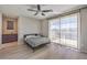 Bright bedroom features a ceiling fan, wood-look floors, and large glass doors to the outside at 406 Gracious Way, Henderson, NV 89011