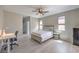 Bright bedroom features a ceiling fan, a bed, desk and chair, and great natural light at 406 Gracious Way, Henderson, NV 89011