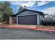 Single Gathering home featuring a dark painted garage and a tidy yard at 4745 Madrigal Way, Las Vegas, NV 89122