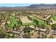 Beautiful aerial view of a community with a golf course, club house, tennis courts and mountain views at 4821 Black Bear Rd # 101, Las Vegas, NV 89149