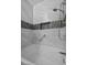 Close up of the tub/shower showing the white marble tile and decorative accent tile at 4821 Black Bear Rd # 101, Las Vegas, NV 89149