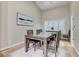Elegant dining room with a wood table, seating for six, and natural light from a window at 4835 Illustrious St, Las Vegas, NV 89147