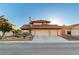 Charming two-story home featuring a three-car garage, tile roof, and desert landscaping in the front yard at 4835 Illustrious St, Las Vegas, NV 89147