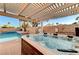 Hot tub under pergola next to pool with desert landscaping in backyard at 4835 Illustrious St, Las Vegas, NV 89147