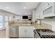 Modern kitchen with granite countertops and stainless steel appliances open to a living room at 4835 Illustrious St, Las Vegas, NV 89147