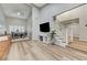 Open-concept living room featuring a staircase, hardwood floors, and an adjacent dining area at 4835 Illustrious St, Las Vegas, NV 89147