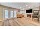 Bright living room boasts a brick fireplace, wood flooring, and French doors to the pool at 4835 Illustrious St, Las Vegas, NV 89147