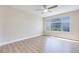Bright bedroom featuring a ceiling fan, wood-style flooring, and a large window offering a pleasant outdoor view at 5217 Caspian Springs Dr # 101, Las Vegas, NV 89120