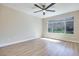 Sunlit bedroom with wood-style floors, a modern ceiling fan, and expansive window to bring the outdoors in at 5217 Caspian Springs Dr # 101, Las Vegas, NV 89120