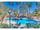Community pool surrounded by palm trees with tables, chairs, and lounge seating for residents' relaxation and enjoyment at 5217 Caspian Springs Dr # 101, Las Vegas, NV 89120