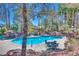Inviting community pool surrounded by lush landscaping, tables and chairs, and mature palm trees at 5217 Caspian Springs Dr # 101, Las Vegas, NV 89120