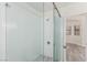 Bright bathroom featuring a glass shower door, mosaic tile floor, and a shower head at 5221 Crooked River Cir, Las Vegas, NV 89149