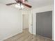 Bright bedroom featuring a ceiling fan, wood flooring, and a closet with gray sliding doors at 5221 Crooked River Cir, Las Vegas, NV 89149