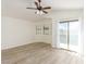 Spacious bedroom featuring a ceiling fan, wood flooring, a large sliding glass door and window with blinds at 5221 Crooked River Cir, Las Vegas, NV 89149
