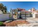 Eye-level angle of the home's facade showing a two-car garage, an entry gate, and well-maintained landscaping at 5221 Crooked River Cir, Las Vegas, NV 89149