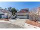 Low angle view of the home's facade, with a two-car garage and a front entrance gate at 5221 Crooked River Cir, Las Vegas, NV 89149