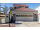 View of the garage and entry gate of this well maintained home featuring a terracotta roof and neutral stucco exterior at 5221 Crooked River Cir, Las Vegas, NV 89149