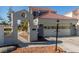 Facade view of home with a two-car garage, an entry gate, and a small, well-manicured front garden at 5221 Crooked River Cir, Las Vegas, NV 89149