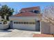 A view of the home's attached garage, with light colored doors, set amongst the neutral exterior of this property at 5221 Crooked River Cir, Las Vegas, NV 89149