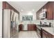 Well-appointed kitchen with stainless steel appliances, dark wood cabinets, mosaic backsplash, and durable stone countertops at 5221 Crooked River Cir, Las Vegas, NV 89149