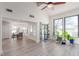 Open-concept living space with gray wood flooring, high ceilings, access to the backyard, and adjacent dining area at 5221 Crooked River Cir, Las Vegas, NV 89149
