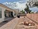 Large backyard with brick paver patio, stone landscaping, and outdoor grill at 5422 Nestled Moon Ct, Las Vegas, NV 89131
