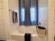 Bathroom featuring a soaking tub with decorative tile accents and window at 5422 Nestled Moon Ct, Las Vegas, NV 89131