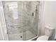 Bathroom featuring a frameless walk-in shower with modern fixtures and marble tile at 5422 Nestled Moon Ct, Las Vegas, NV 89131
