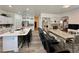 Open-concept dining area with large island and barstool seating seamlessly connected to living room at 5422 Nestled Moon Ct, Las Vegas, NV 89131
